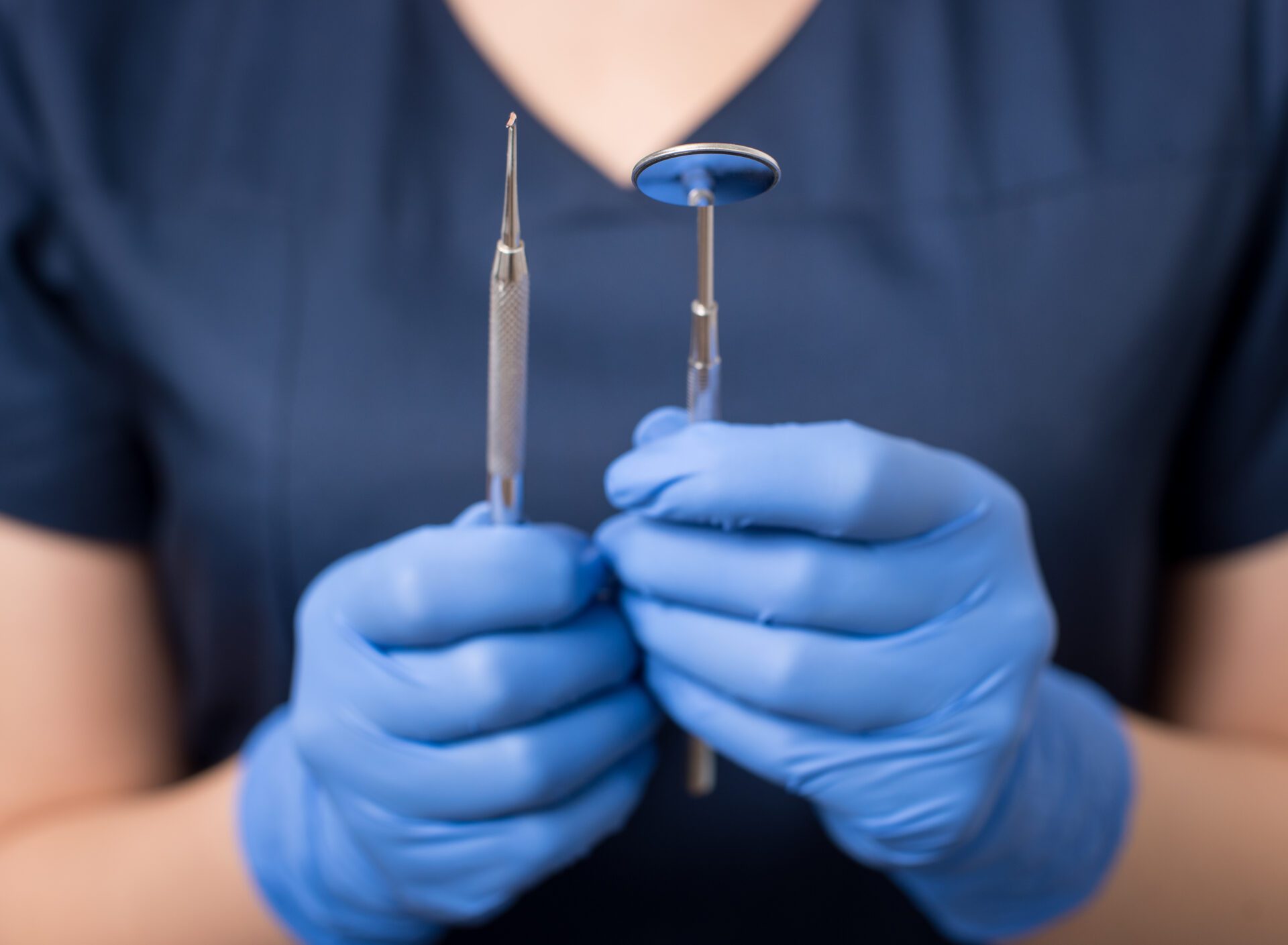 Bradenton Dentist with blue gloves holding tools